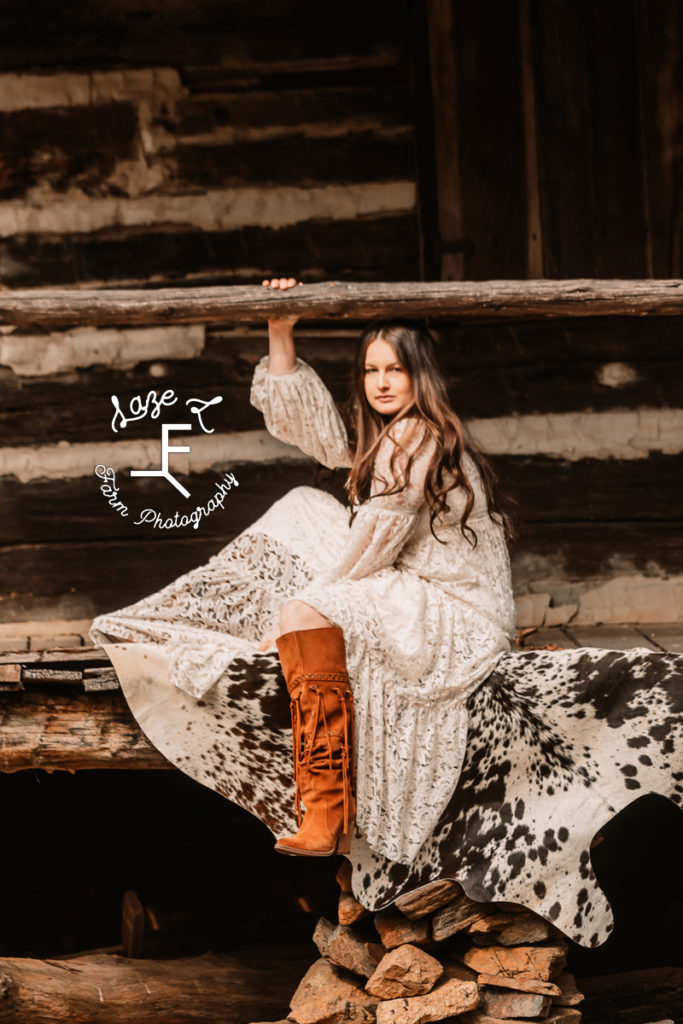 girl in lace western style dress at log cabin