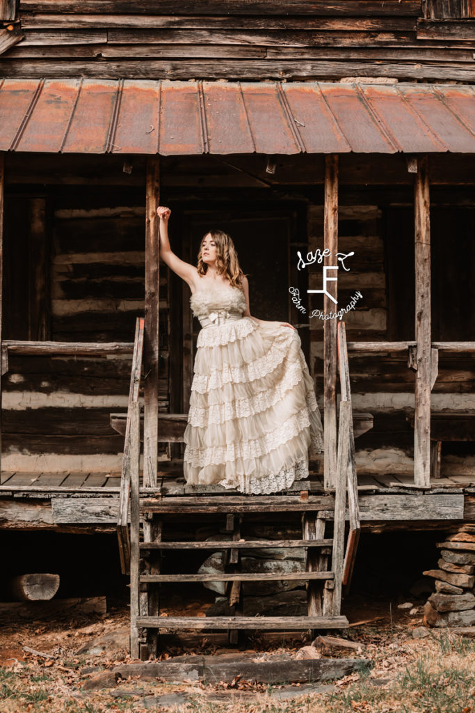 girl in vintage western dress at log cabin