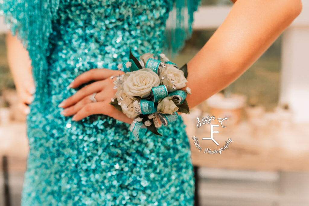 close up of corsage, nails and sequins on dress