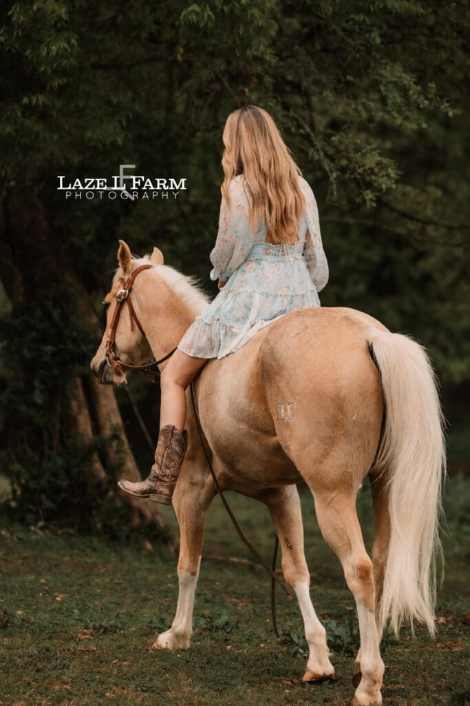 girl riding her horse away from the camera