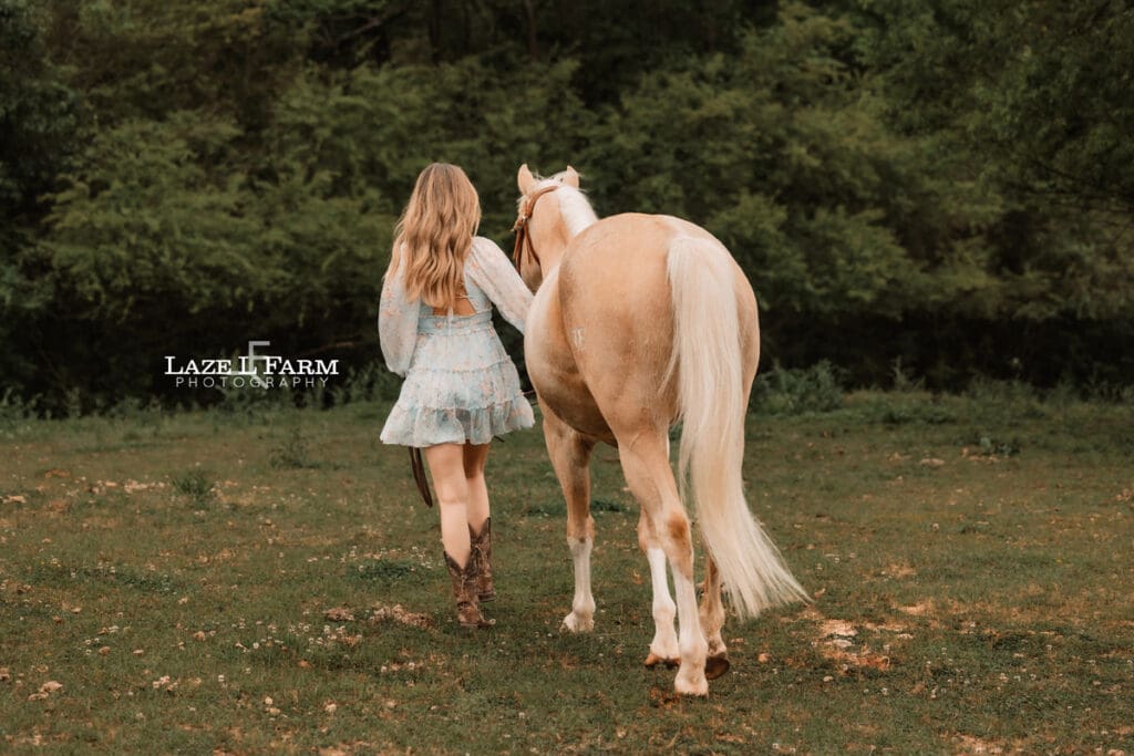 girl and horse walking away from the camera