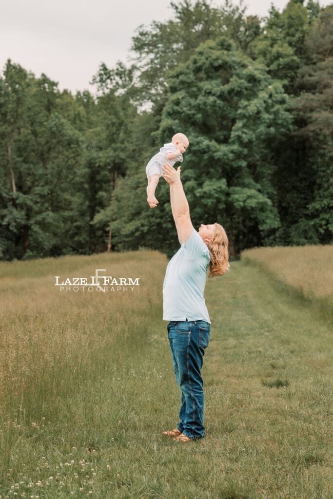 dad holding son up in the air for family pictures