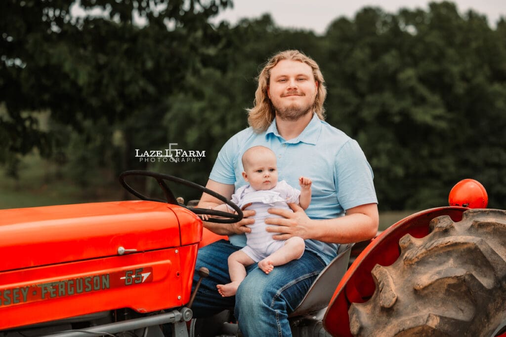 Dad and son sitting on an old tractor for family pictures