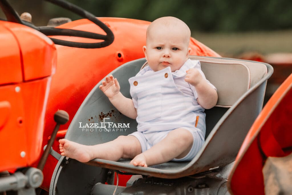 son sitting on tractor seat for family pictures