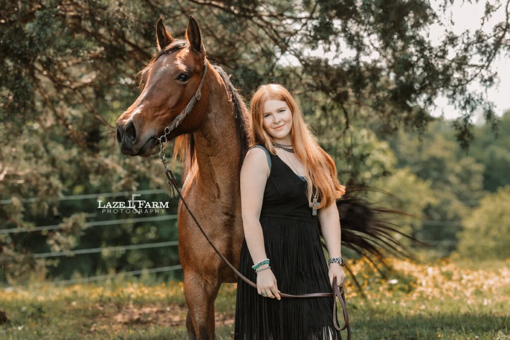cowgirl standing beside of her horse