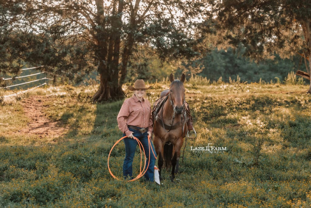 cowgirl standing beside of her horse