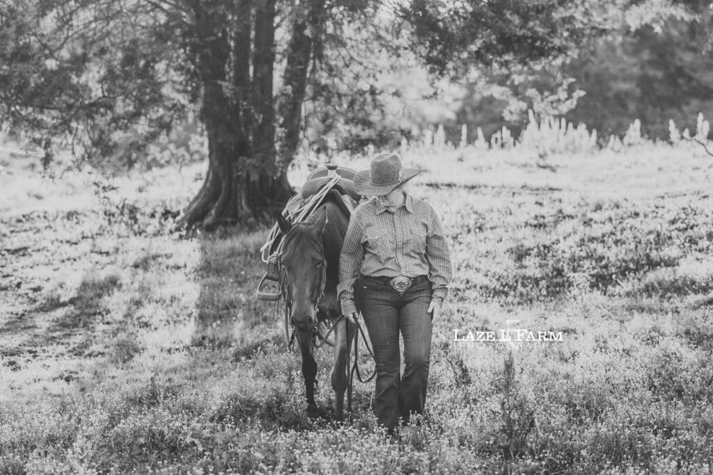 cowgirl walking with her horse