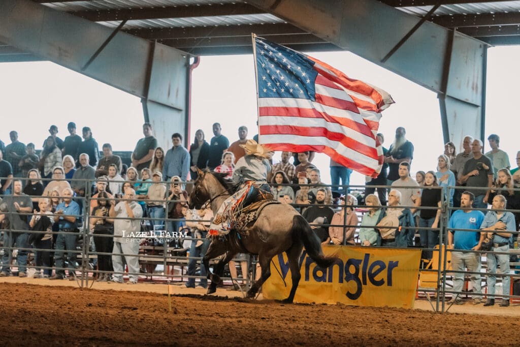 cowgirl carrying the american flag