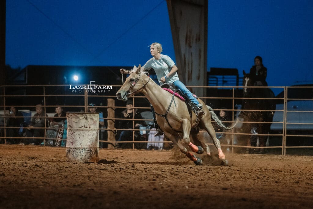 cowgirl barrel racing on a palomino horse