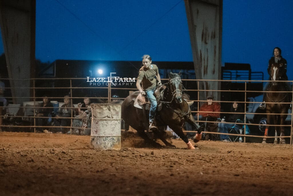 cowgirl barrel racing on a black horse