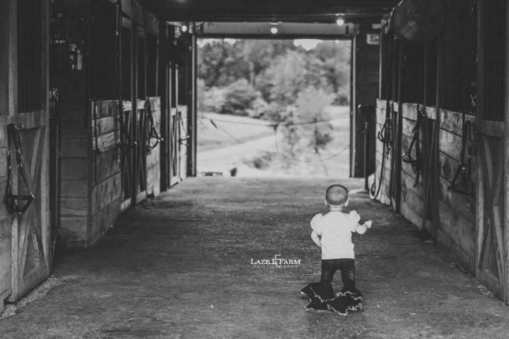 a little girl walking through the barn
