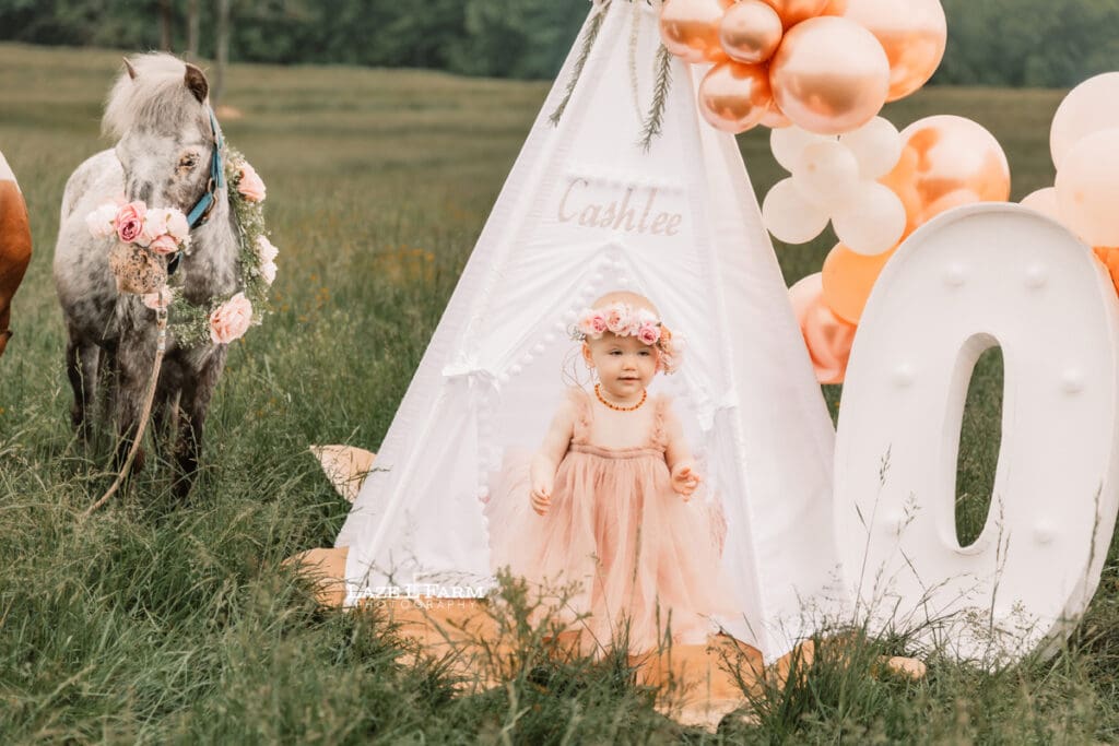a little girl wearing a dress for her 1st birthday photoshoot