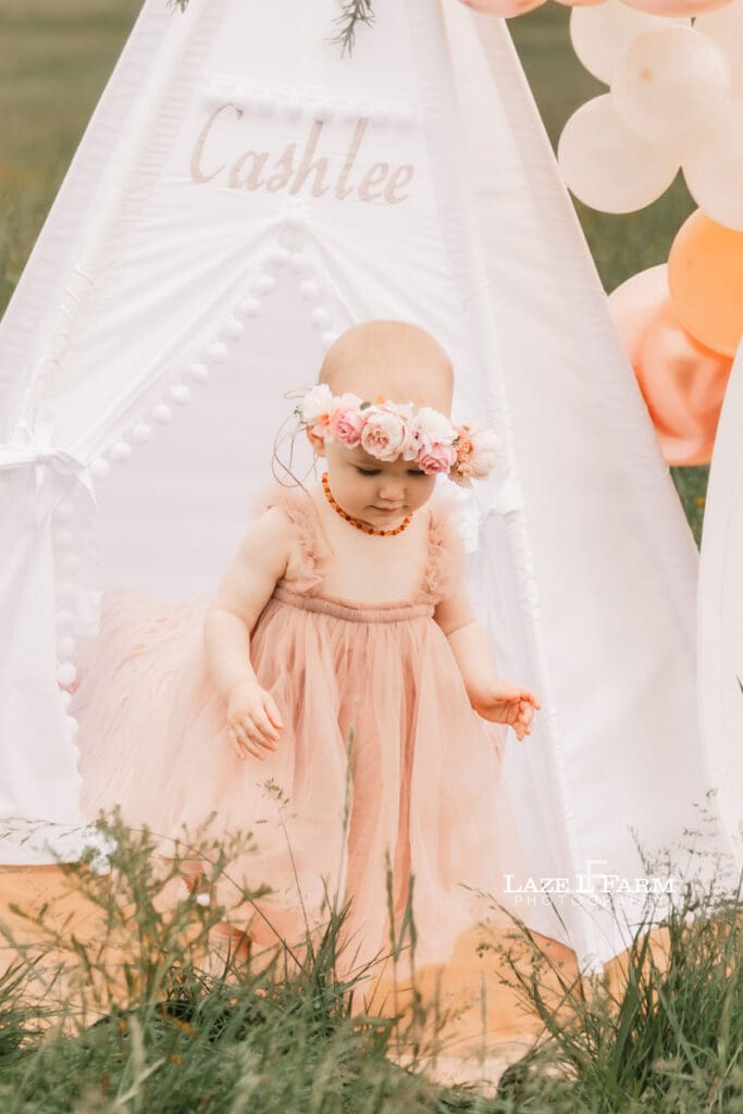 a little girl wearing a dress for her 1st birthday photoshoot