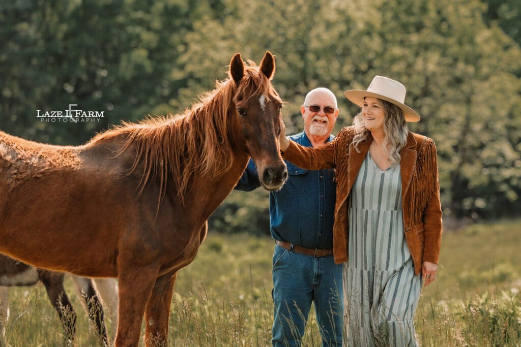 couple standing with their horses at sunset on the mountain for an equine photoshoot
