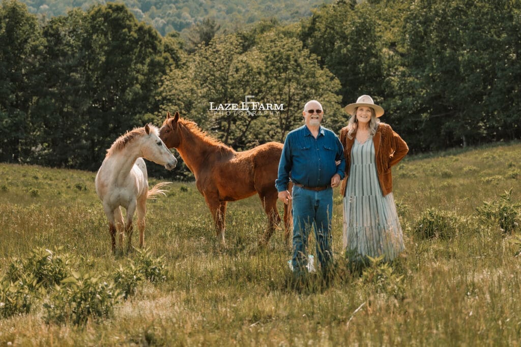 couple standing with their horses at sunset on the mountain for an equine photoshoot