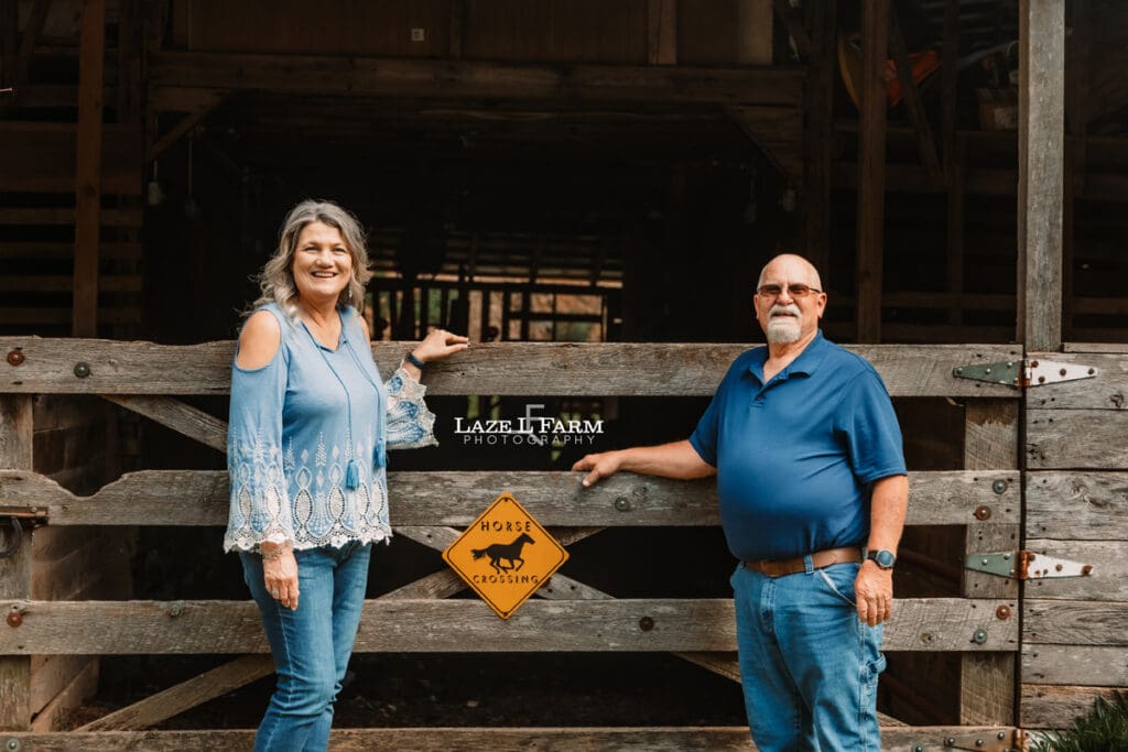 couple standing in front of their barn during family pictures
