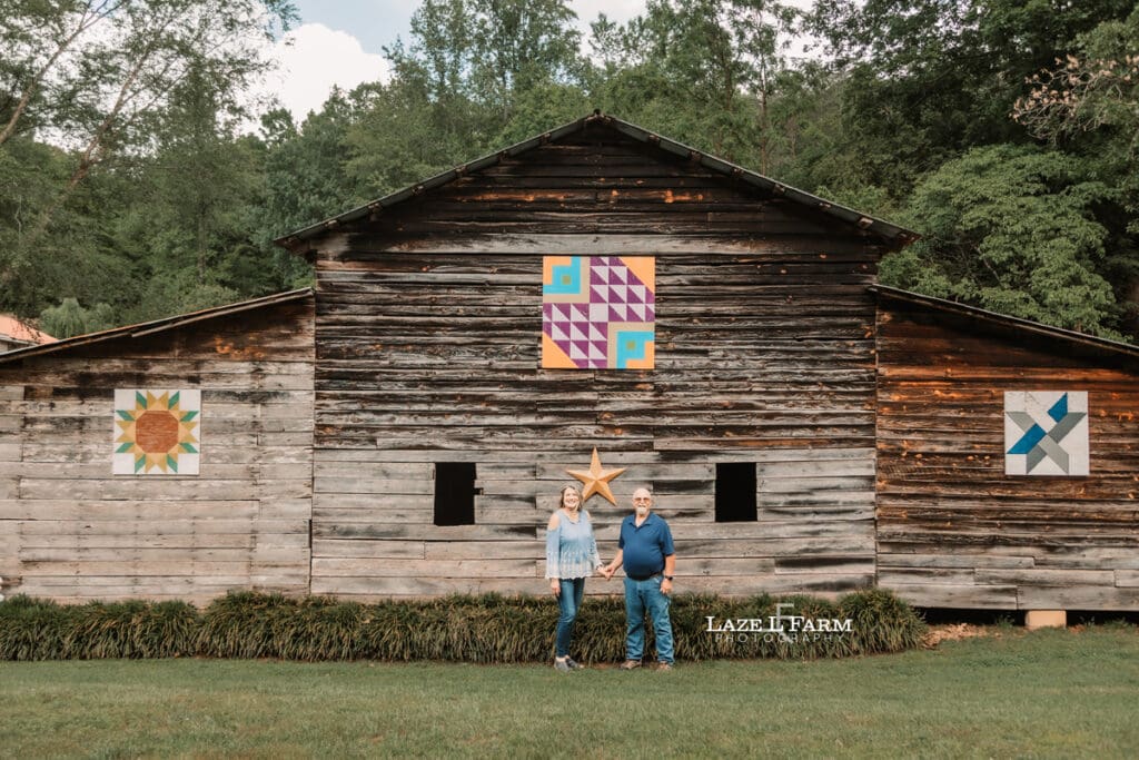 couple standing in front of their barn during family pictures