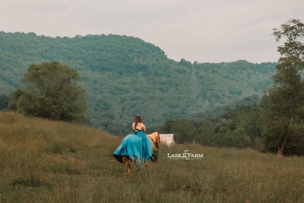 cowgirl riding her horse in a big flowy dress in the mountains