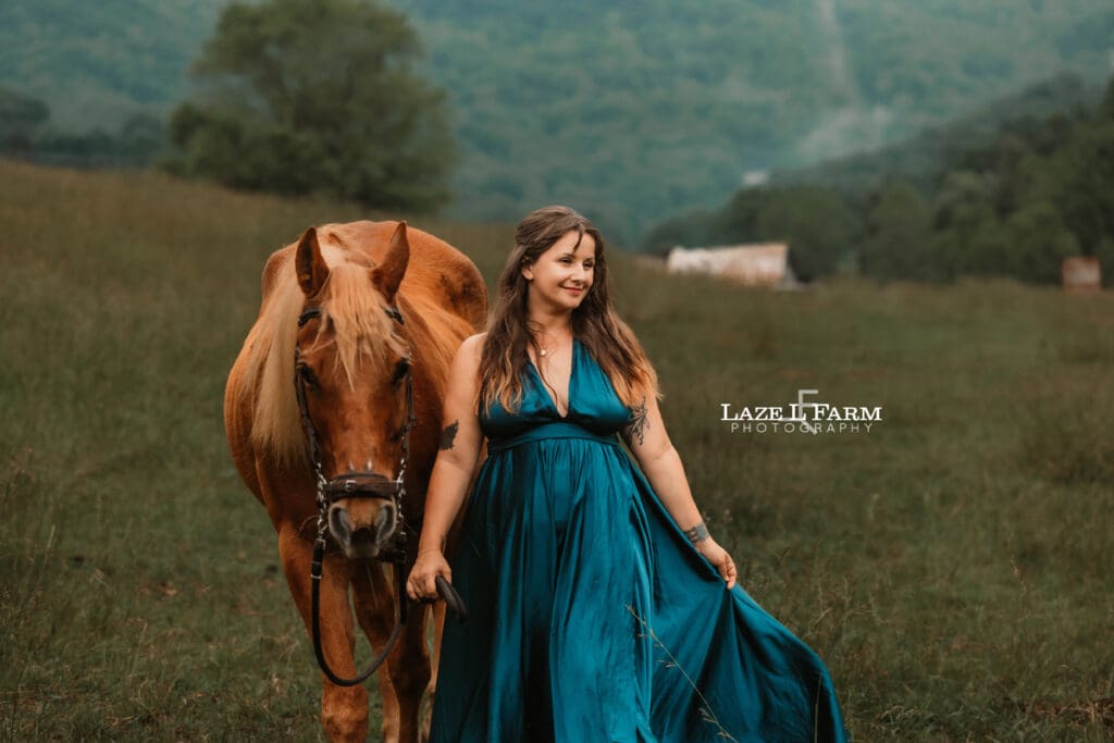 girl walking with her horse in a beautiful field with mountains