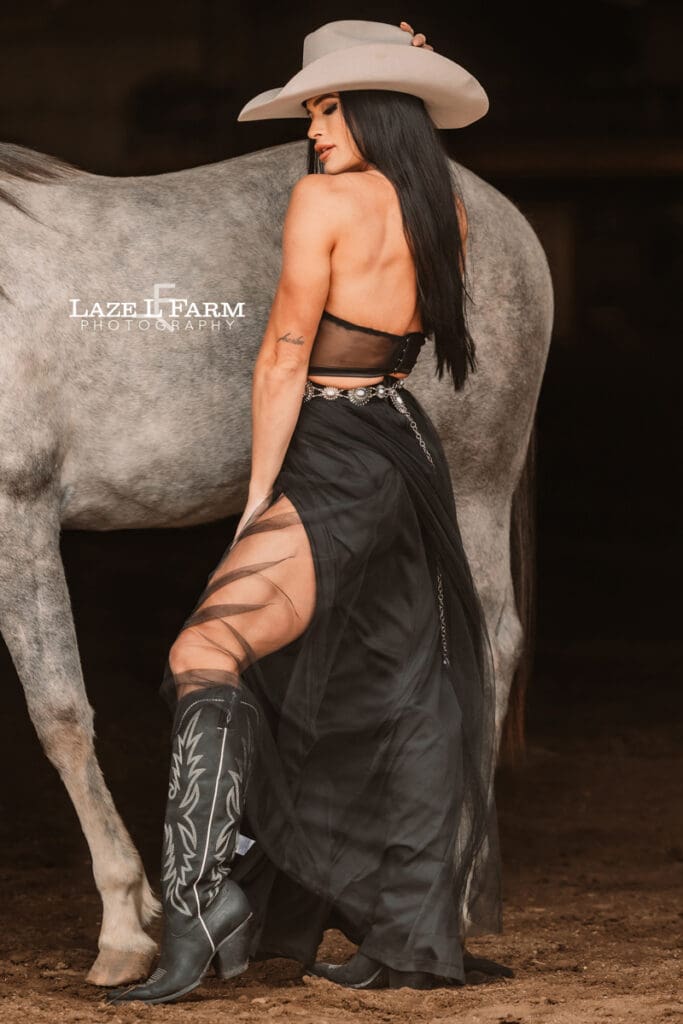 cowgirl facing the horse with her head turned