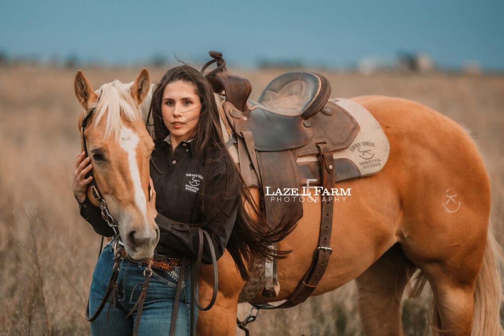 cowgirl and her palomino horse in a field
