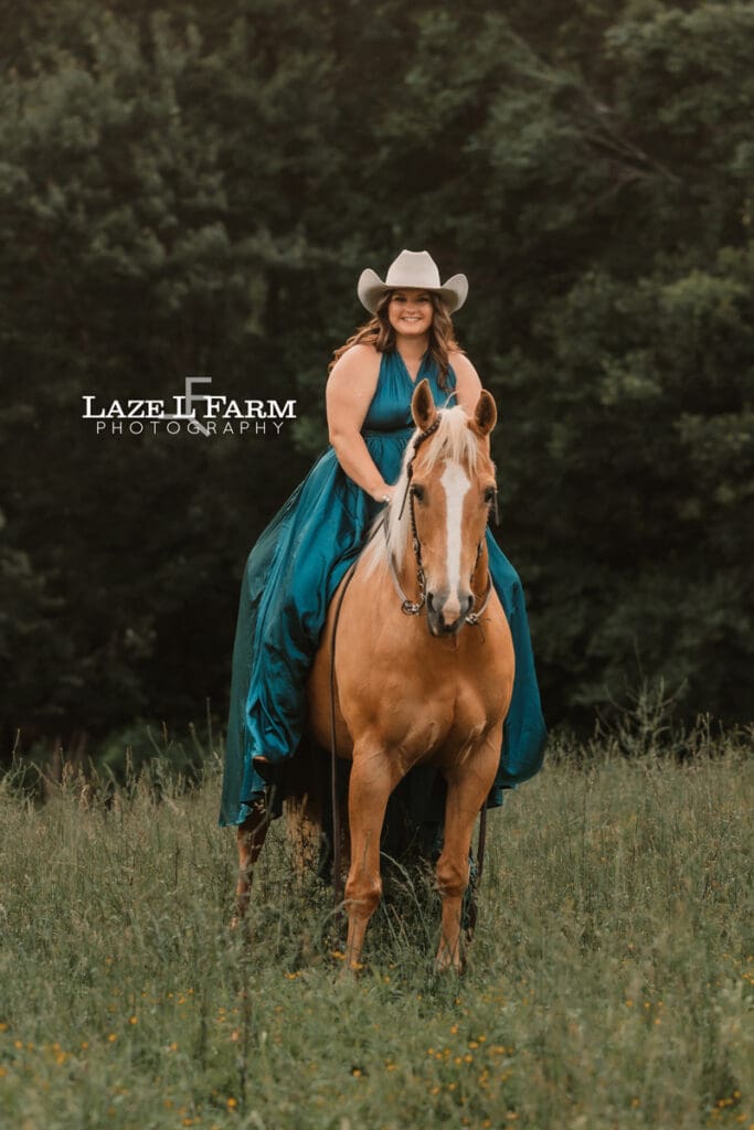 cowgirl in a turquoise parachute dress with her horse