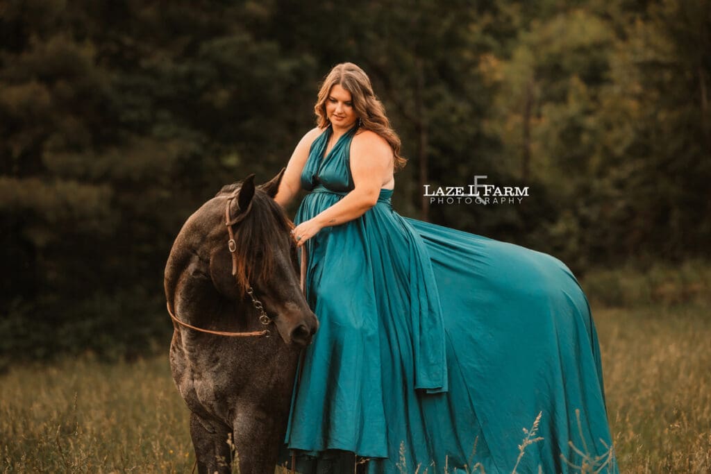 cowgirl in a turquoise parachute dress with her horse