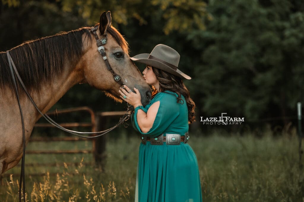 cowgirl kissing her horse on the nose