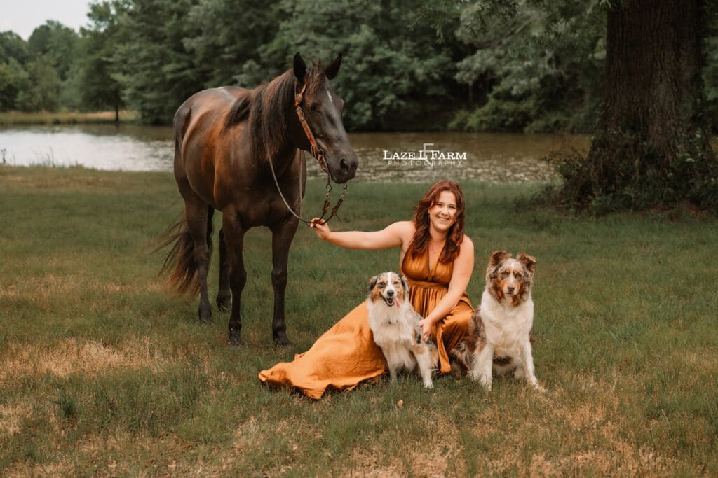 Cowgirl with her horse and dogs