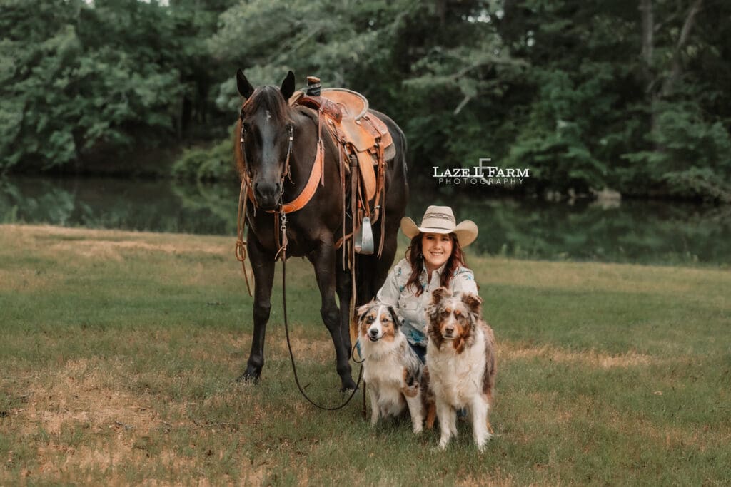 cowgirl with her horse and dogs