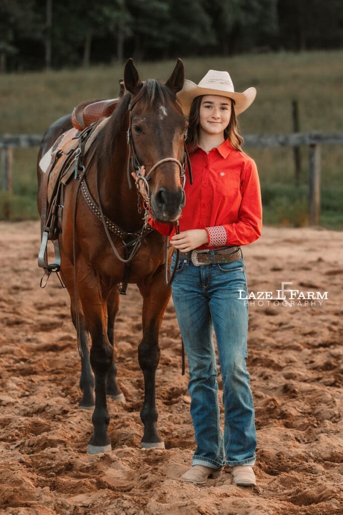 cowgirl standing beside of her horse
