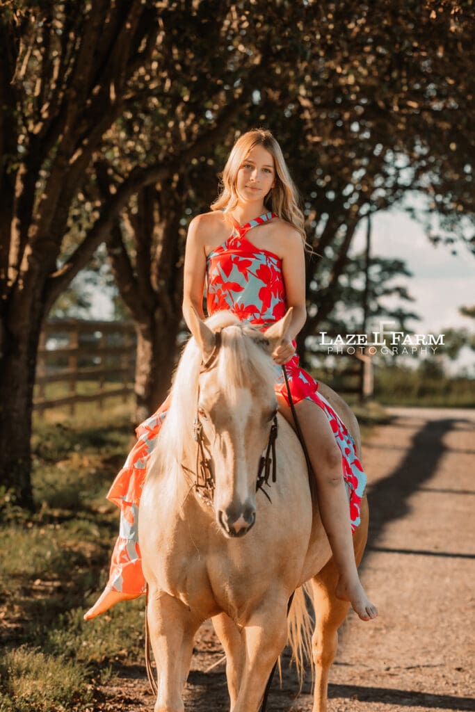 girl riding her palomino horse in a dress