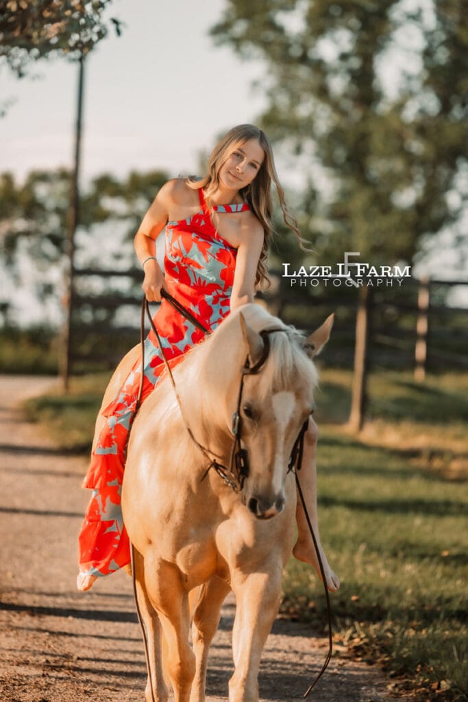 girl riding her palomino horse in a dress