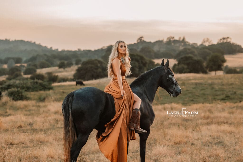 cowgirl with flowy parachute dress on the back of a horse