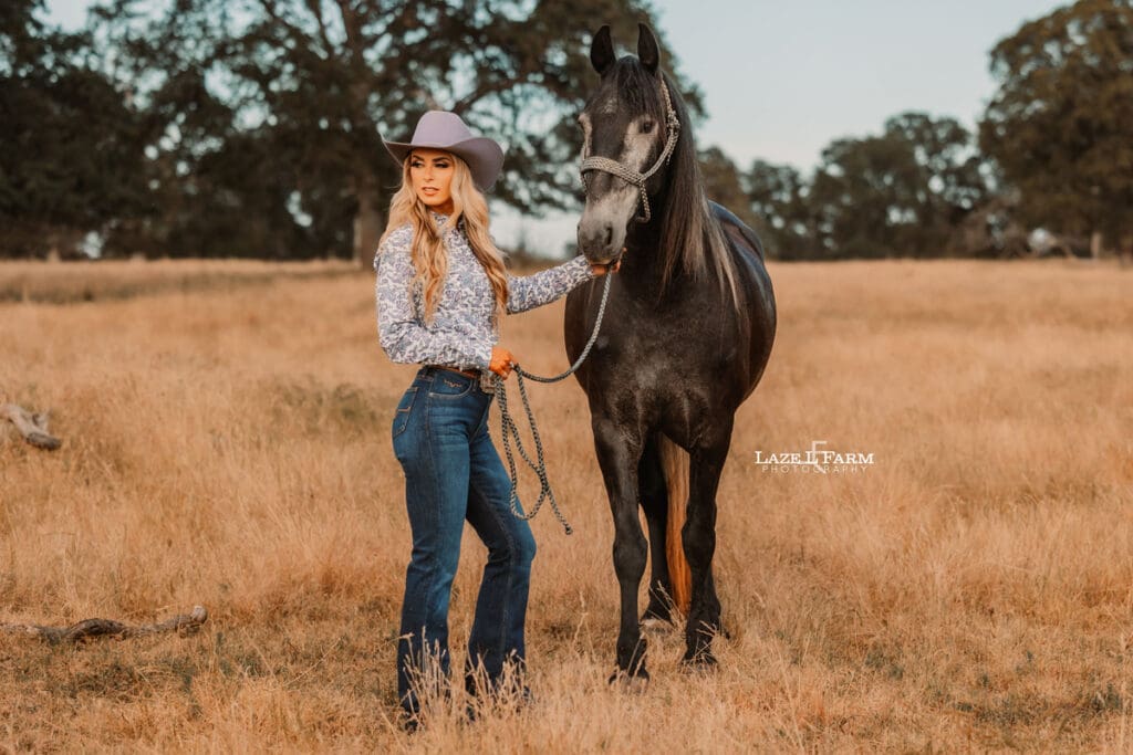 cowgirl and her horse standing in a field