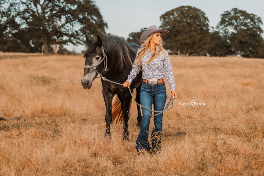 cowgirl and her horse standing in a field