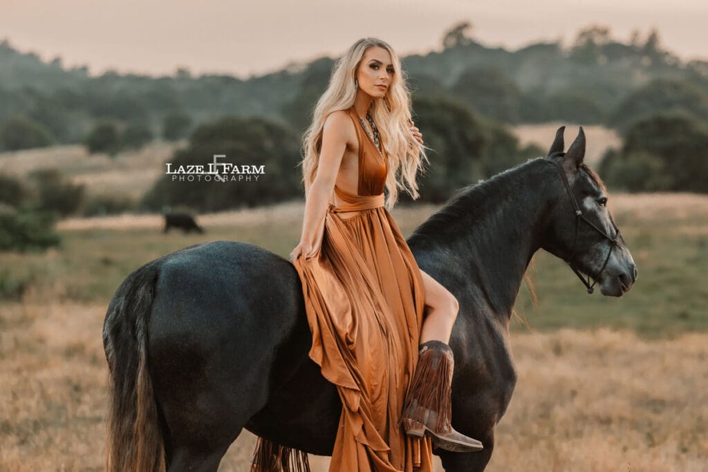 cowgirl with flowy parachute dress on the back of a horse