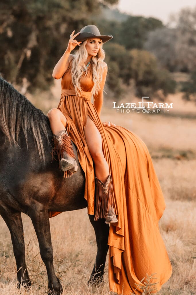 cowgirl with flowy parachute dress on the back of a horse