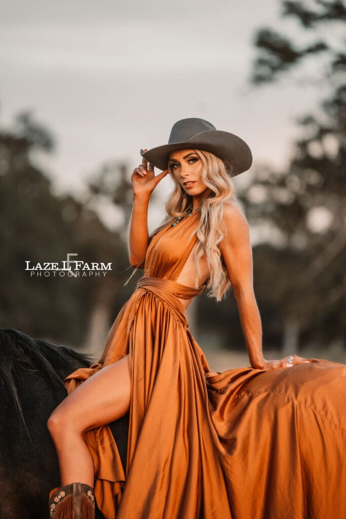 cowgirl with flowy parachute dress on the back of a horse