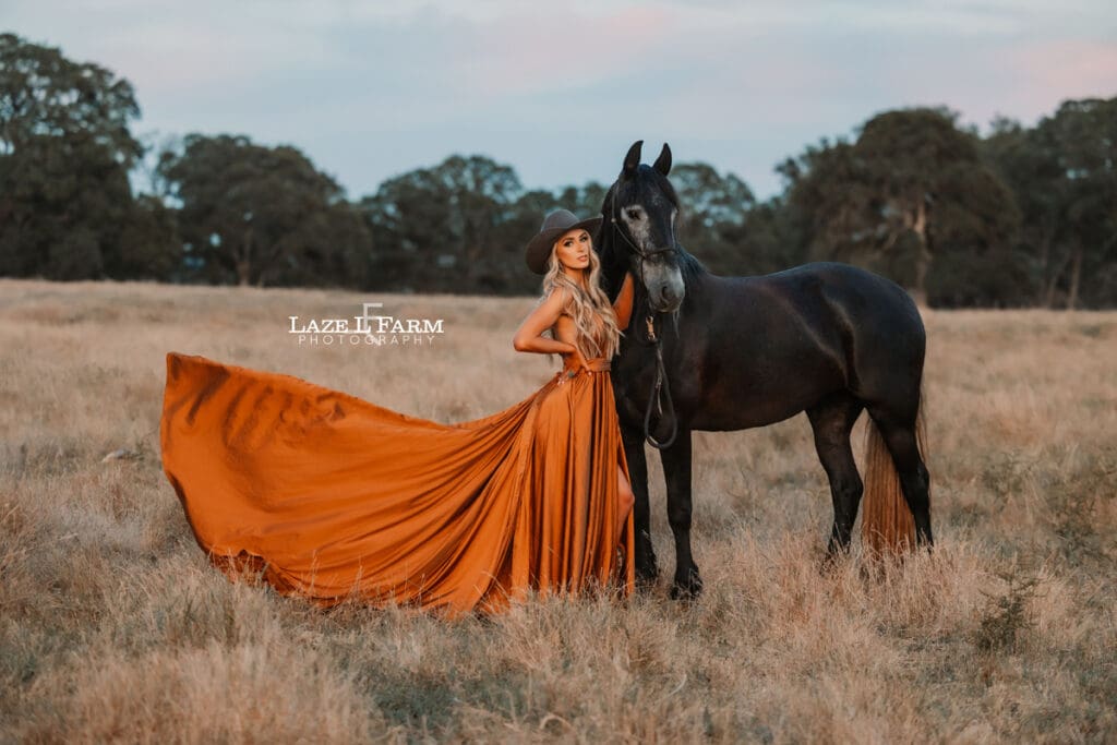 cowgirl with flowy parachute dress on the back of a horse