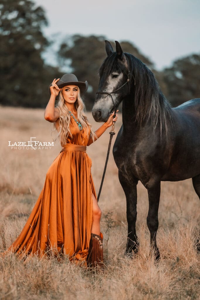 cowgirl with flowy parachute dress on the back of a horse