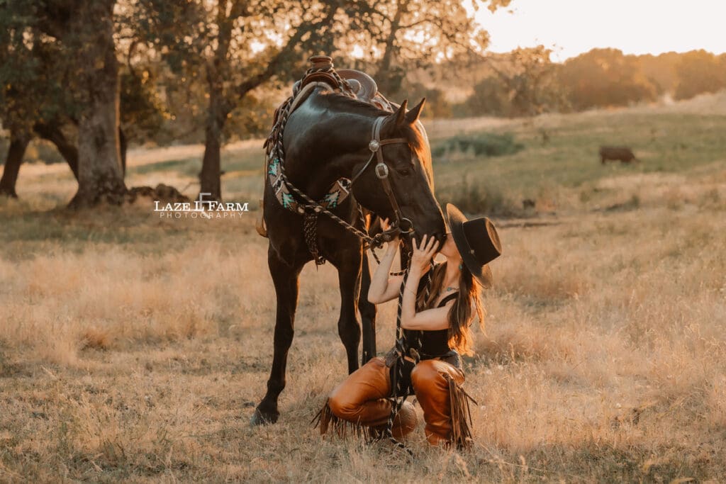 cowgirl kissing her horse on the nose