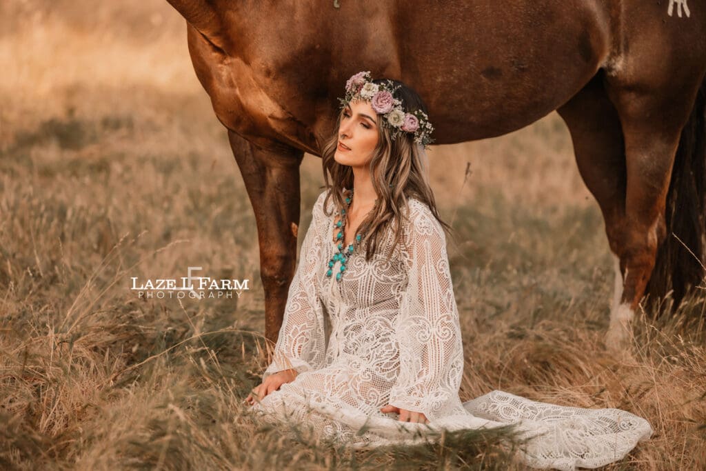 cowgirl with a lacy dress with flowers in her with a horse