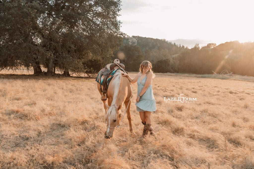 a girl with her horse in a field at sunset