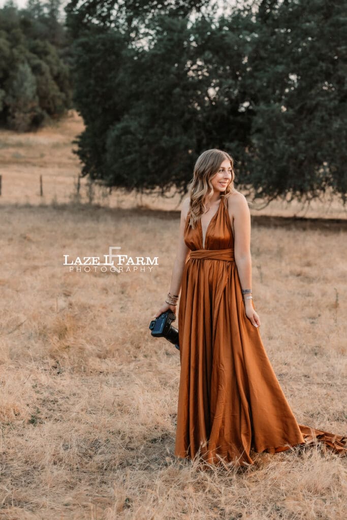 girl in a parachute dress in a field with her camera