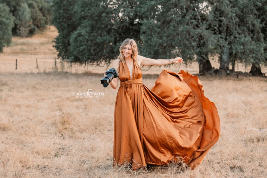 girl in a parachute dress in a field with her camera