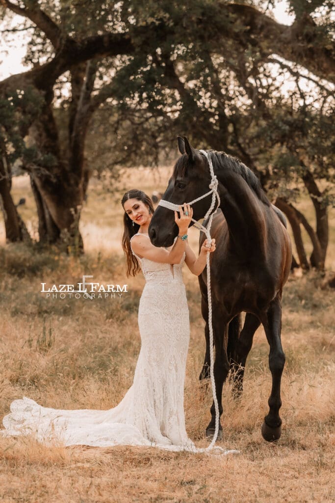cowgirl in a wedding dress with her horse in a field