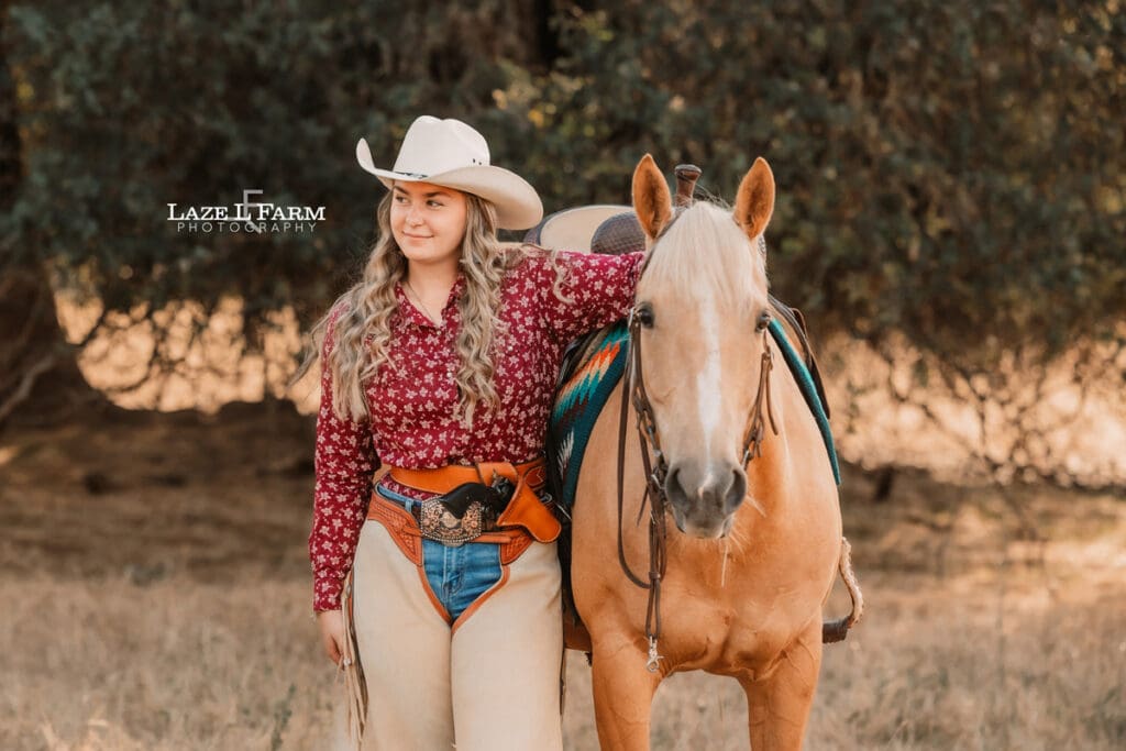 cowgirl standing with her horse