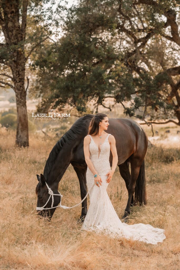 cowgirl in a wedding dress with her horse in a field