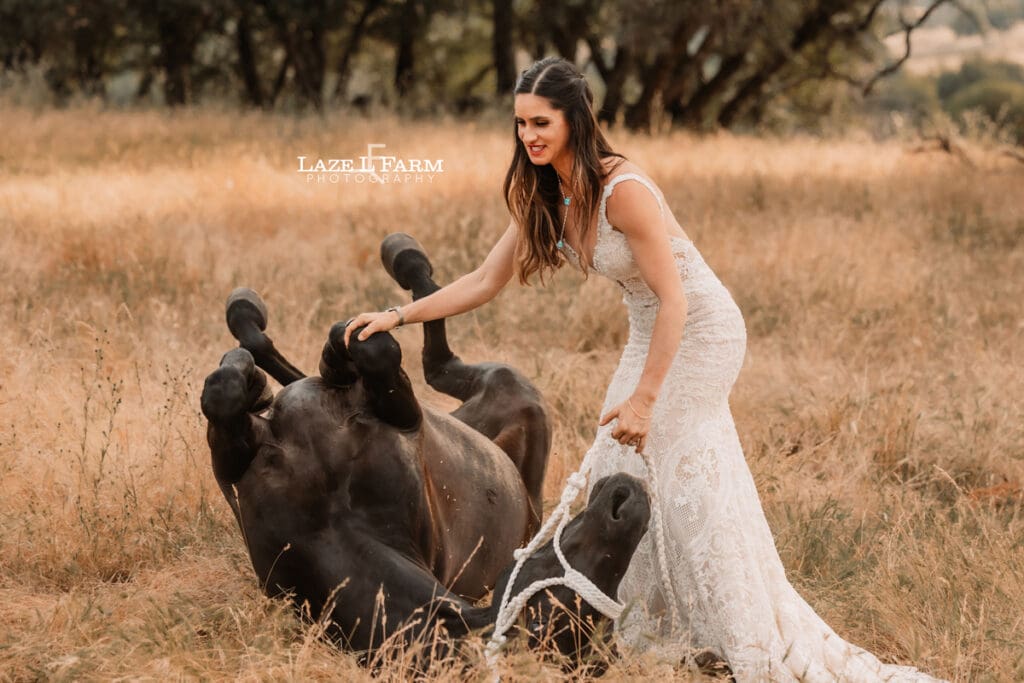 cowgirl in a wedding dress with her horse in a field